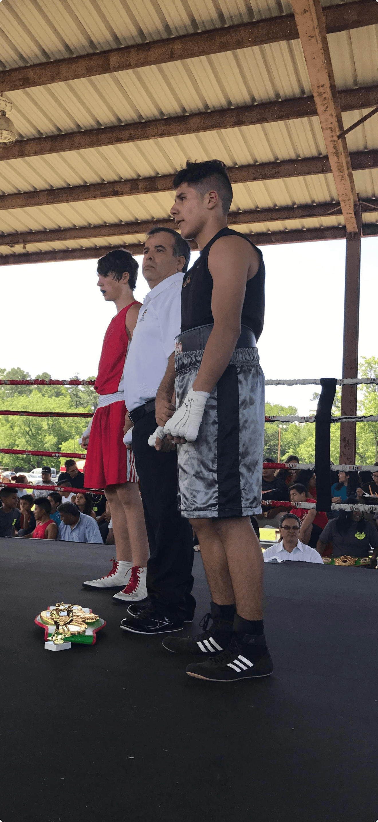 Fighters and a referee in the ring after a bout